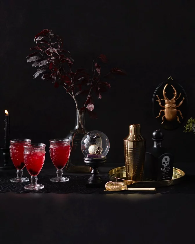 Beautiful and bewitching Halloween decor with golden beetles, glass goblets, and more. 