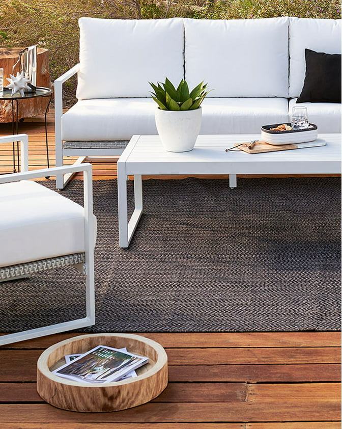 A modern white outdoor conversation set on a wooden patio. Links to patio furniture on dxoffersmall.com.