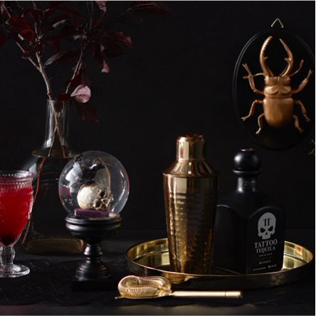 Beautiful and bewitching Halloween decor with golden beetles, glass goblets, and more. 